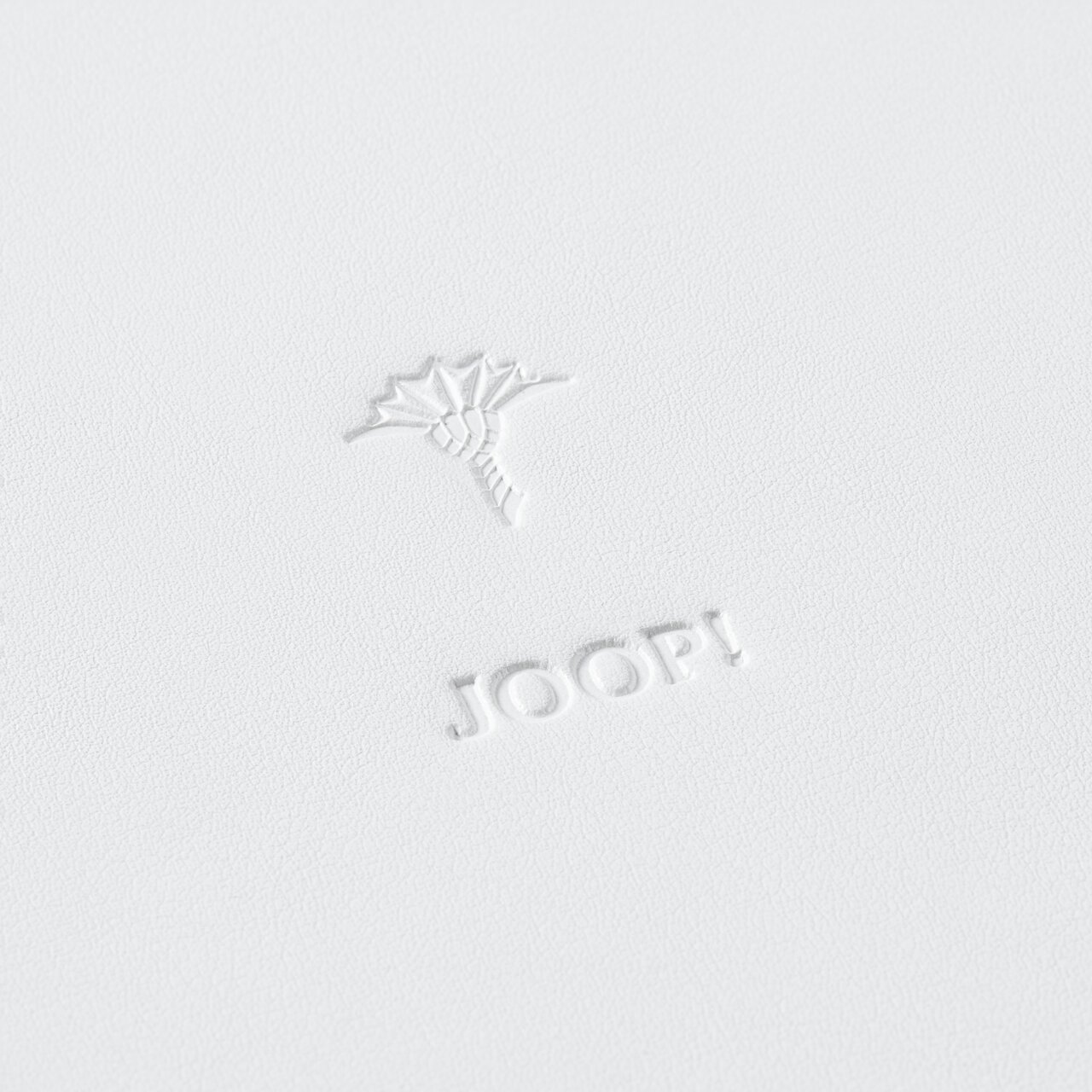 Nahaufnahme eines großen, weißen runden Tabletts mit geprägtem Logo und Blumenmotiv.