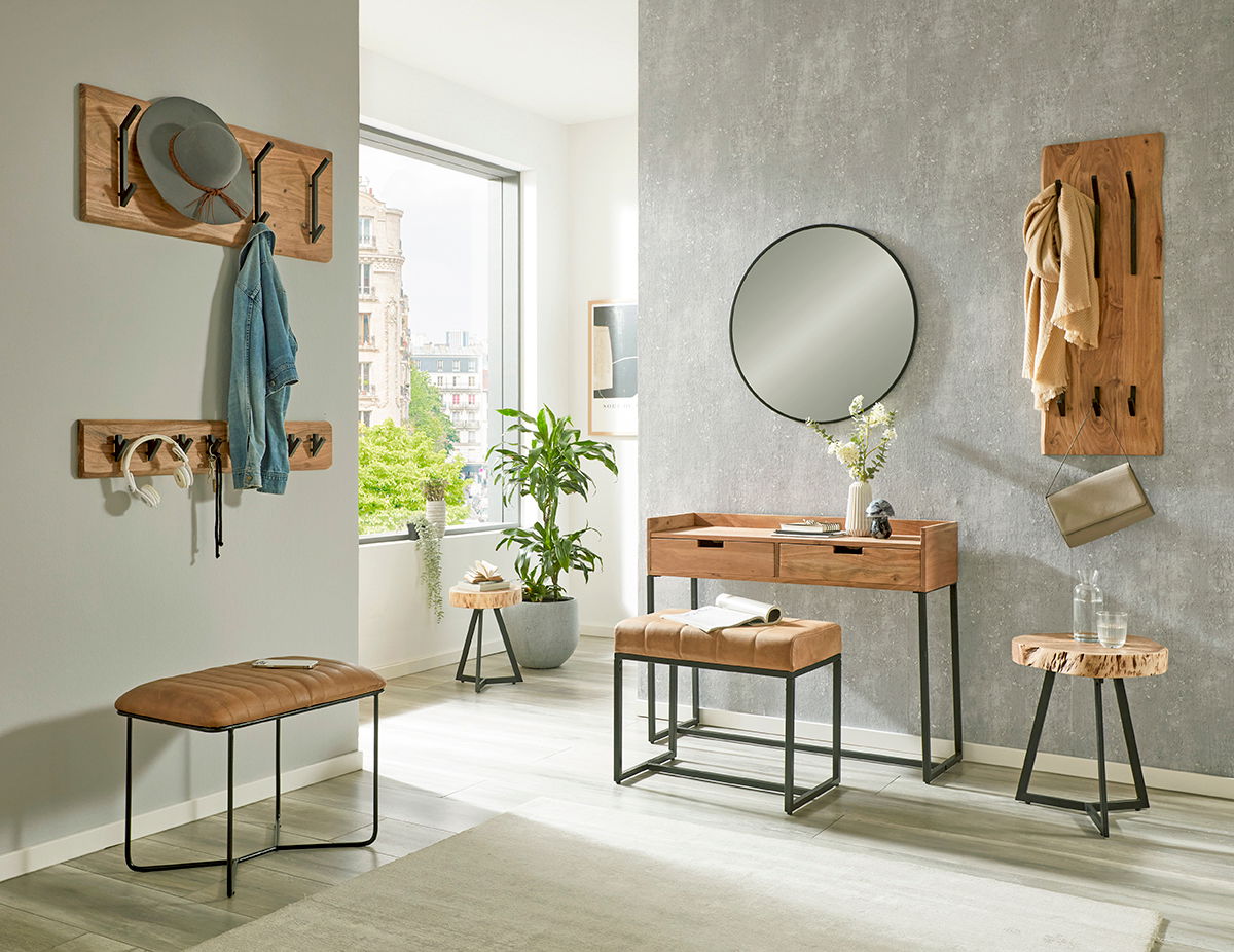 Moderne Konsole aus Holz mit Metallgestell, umgeben von stilvollen Wandhaken und einem runden Spiegel, in einem hellen Raum mit Blick auf die Stadt.