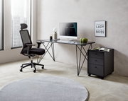 Moderner Schreibtisch mit schwarzem Metallgestell, von der Seite fotografiert, mit Bürostuhl, Computer und Dekorationen in einem hellen Raum.