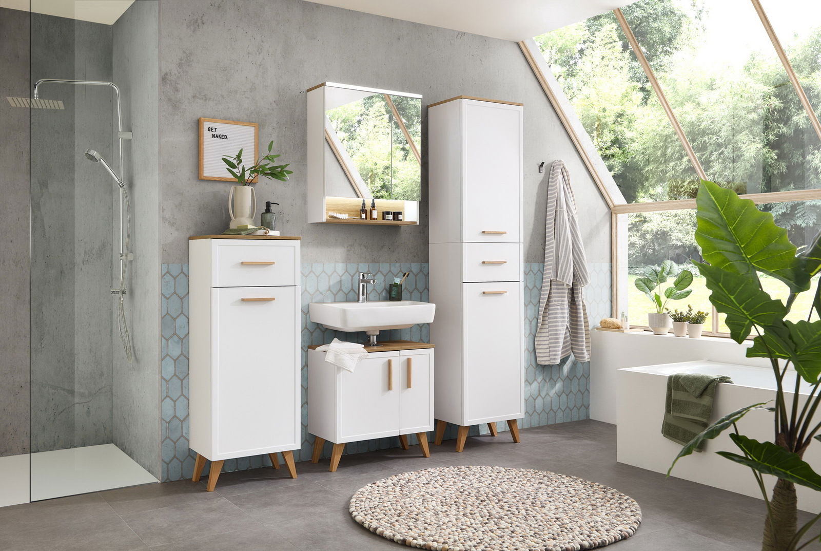 Moderner Badezimmer-Spiegelschrank in einem hellen, stilvollen Badezimmer mit großen Fenstern und grünen Pflanzen, aus der Perspektive von vorne.