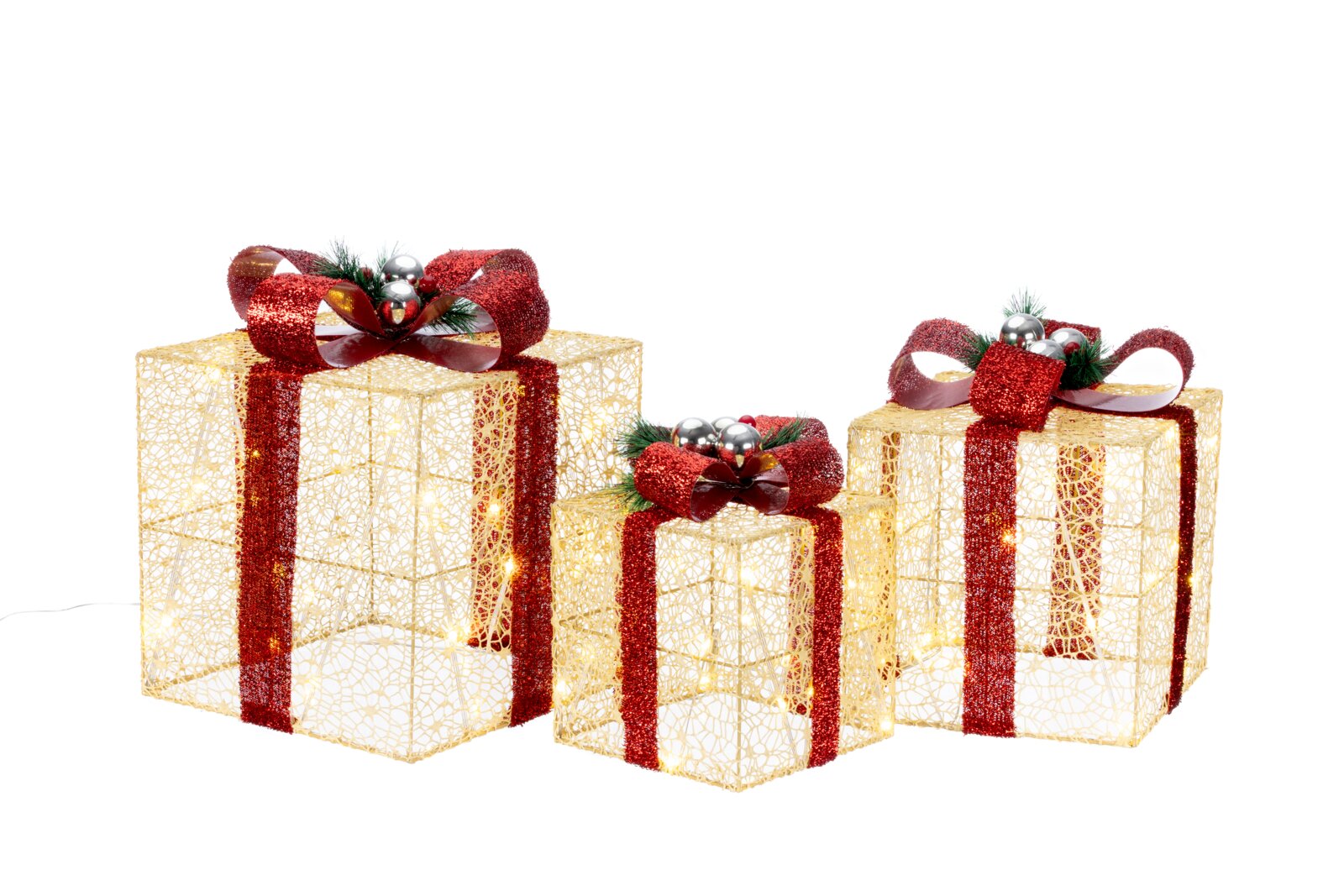 Drei beleuchtete, goldene Draht-Geschenkboxen mit roten Glitzerbändern und Schleifen, dekoriert mit Tannengrün und silbernen Kugeln, freigestellt auf weißem Hintergrund, Ansicht leicht von vorne oben.