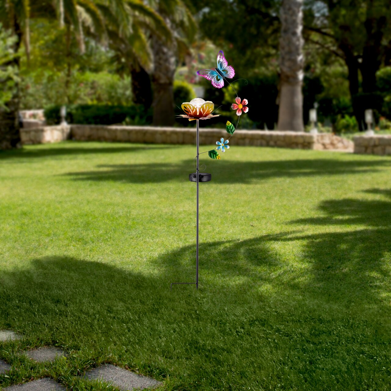 Zonne-lamp in de vorm van een bloem met een vlinder en bloemversiering, geplaatst in een tuin, zijaanzicht