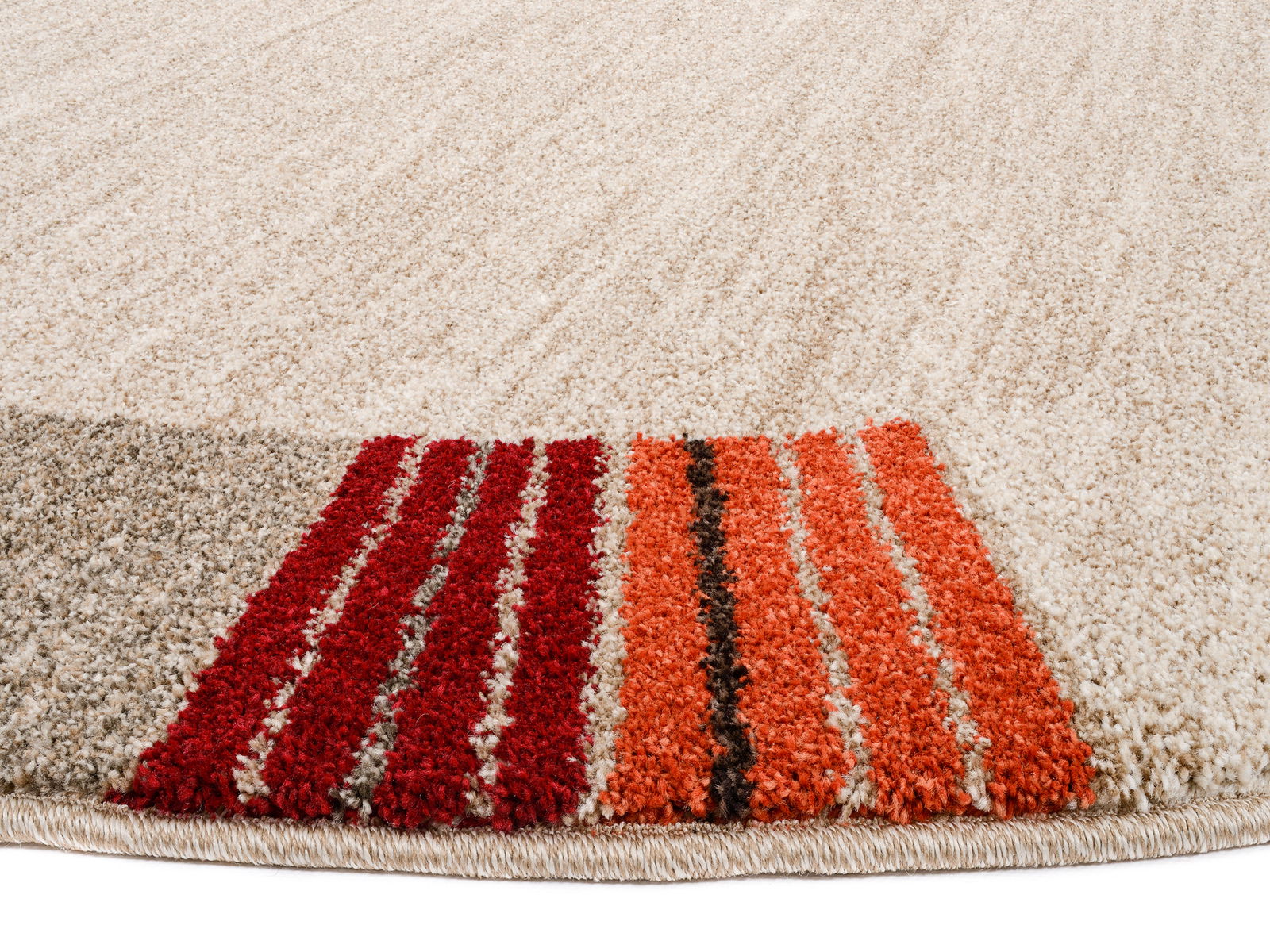 Nahaufnahme eines runden Frisé-Teppichs mit cremefarbenem Hintergrund und roten, orangen sowie braunen Streifen am Rand.