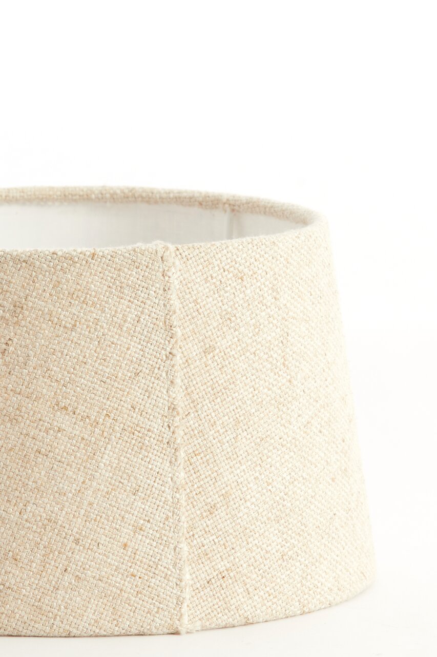 Nahaufnahme eines beige-farbenen, runden Lampenschirms mit texturierter Oberfläche, seitliche Perspektive.