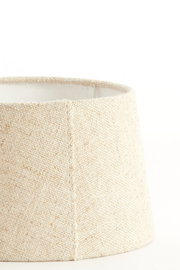 Nahaufnahme eines beige-farbenen, runden Lampenschirms mit texturierter Oberfläche, seitliche Perspektive.