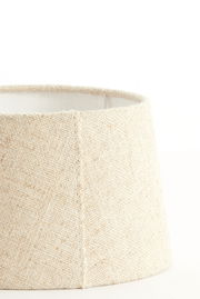 Nahaufnahme eines beige-farbenen, runden Lampenschirms mit texturierter Oberfläche, seitliche Perspektive.