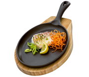 BBQ Servierpfanne mit Holzbrett, von oben fotografiert, mit gegrilltem Fisch, Zitronenscheibe und Gemüse dekoriert.