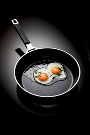 Bratpfanne mit einem Durchmesser von 24 cm, von oben fotografiert, mit zwei Spiegeleiern und Schnittlauch garniert.