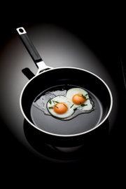 Bratpfanne mit einem Durchmesser von 24 cm, von oben fotografiert, mit zwei Spiegeleiern und Schnittlauch garniert.