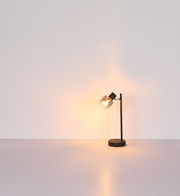 Moderne Tischleuchte mit schwarzem Standfuß und transparentem Lampenschirm, seitliche Perspektive