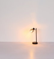 Moderne Tischleuchte mit schwarzem Standfuß und transparentem Lampenschirm, seitliche Perspektive