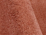 Nahaufnahme eines rosafarbenen Uni-Teppichs mit weicher Textur, seitliche Perspektive