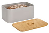 Grauer Brotkasten mit abgenommenem Bambusdeckel, gefüllt mit einem Laib Brot, aus seitlicher Perspektive.