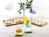 Vier Whiskybecher Elysia auf Tabletts, mit einem gefüllten Glas im Vordergrund, seitliche Perspektive.