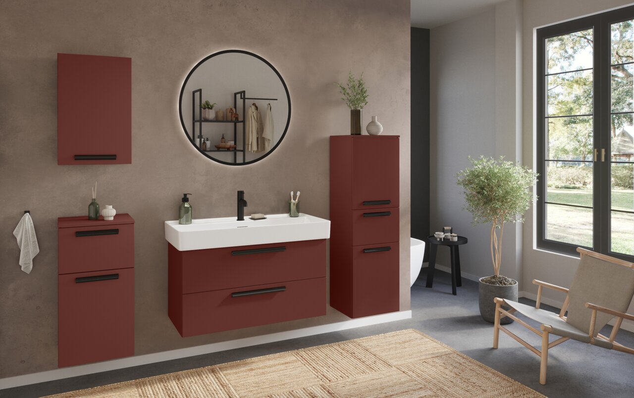 Moderner Badezimmer-Hängeschrank in Rot mit schwarzem Griff, frontal betrachtet, Teil eines stilvollen Badezimmersetups mit Spiegel und Waschbecken.