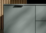 Nahaufnahme eines modernen XL-Sideboards in mattem Grün mit minimalistischen Griffen, seitliche Perspektive
