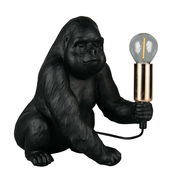 Schwarze Tischleuchte in Form eines Gorillas, der eine Glühbirne in der Hand hält. Perspektive von vorne.