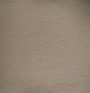 Nahaufnahme einer beige strukturierten Lederoberfläche, die für einen Armlehnstuhl verwendet wird.