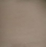 Nahaufnahme einer beige strukturierten Lederoberfläche, die für einen Armlehnstuhl verwendet wird.