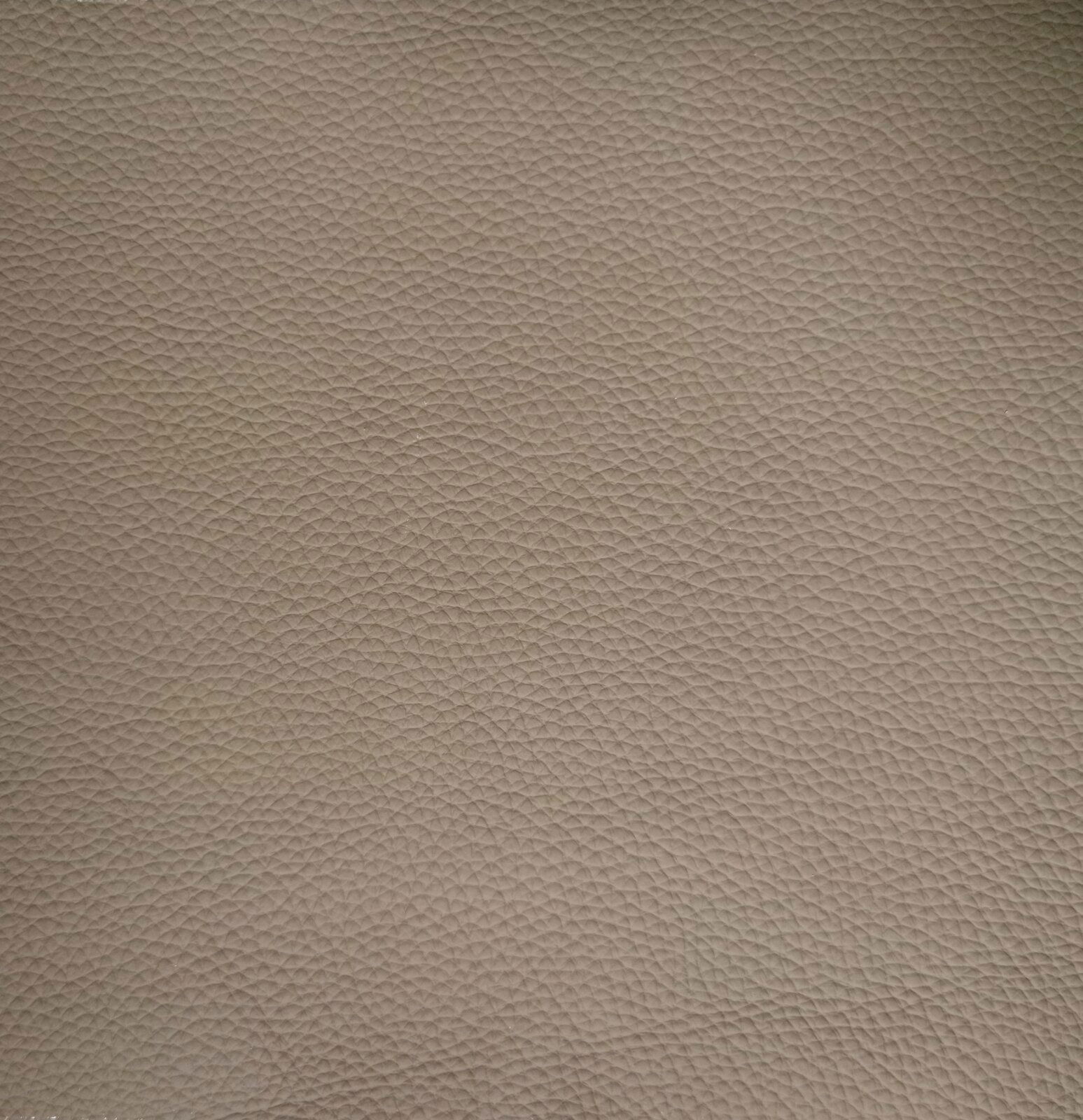 Nahaufnahme einer beige strukturierten Lederoberfläche, die für einen Armlehnstuhl verwendet wird.