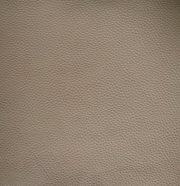 Nahaufnahme einer beige strukturierten Lederoberfläche, die für einen Armlehnstuhl verwendet wird.