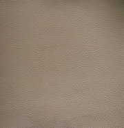 Nahaufnahme einer beige strukturierten Lederoberfläche, die für einen Armlehnstuhl verwendet wird.