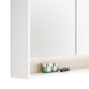 Nahaufnahme eines weißen Spiegelschranks mit zwei Glastiegeln und einer Brille auf einem Regalbrett, seitliche Perspektive