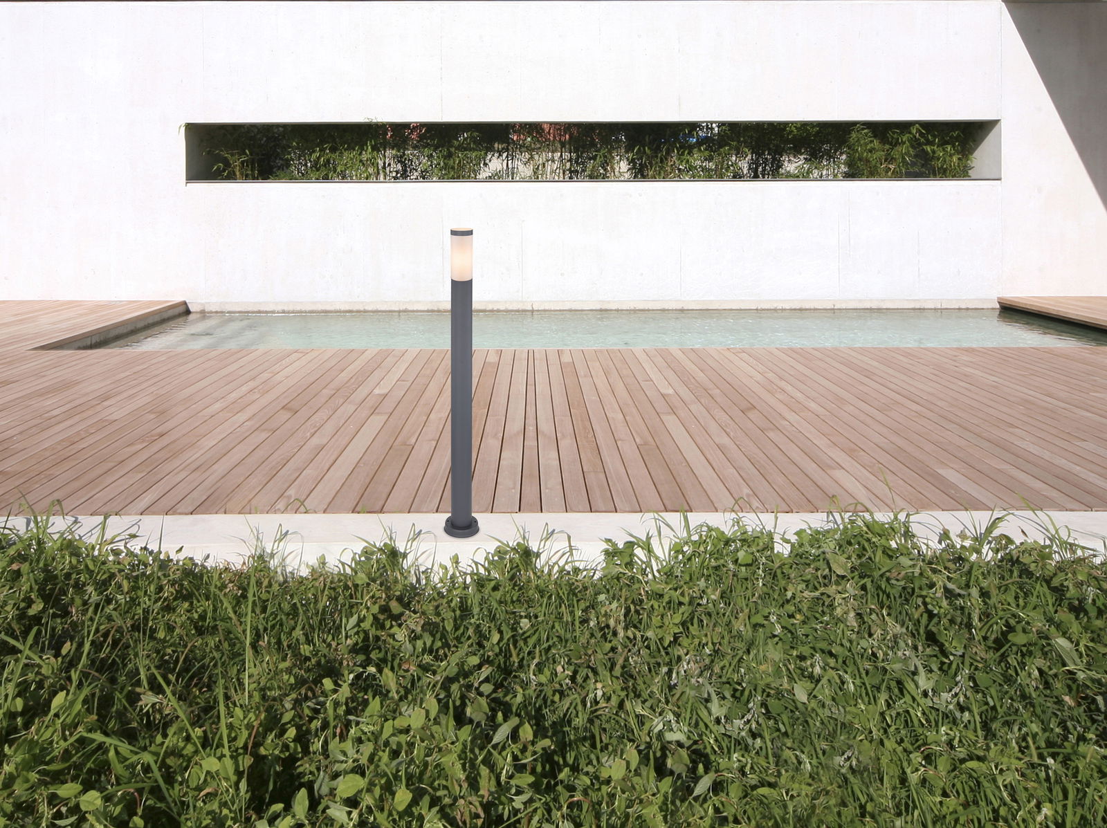 Moderne Außenleuchte BOSTON auf einer Holzterrasse mit Blick auf einen Pool und eine grüne Hecke im Hintergrund.