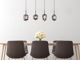 Moderne Hängeleuchte BLACKY mit vier rauchgrauen Glaskugeln über einem Esstisch, seitliche Perspektive.