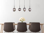 Moderne Hängeleuchte BLACKY mit vier rauchgrauen Glaskugeln über einem Esstisch, seitliche Perspektive.