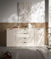 Modernes XL-Sideboard in heller Farbe mit vier Schubladen und zwei Türen, dekoriert mit Büchern und einer Vase, seitliche Perspektive.