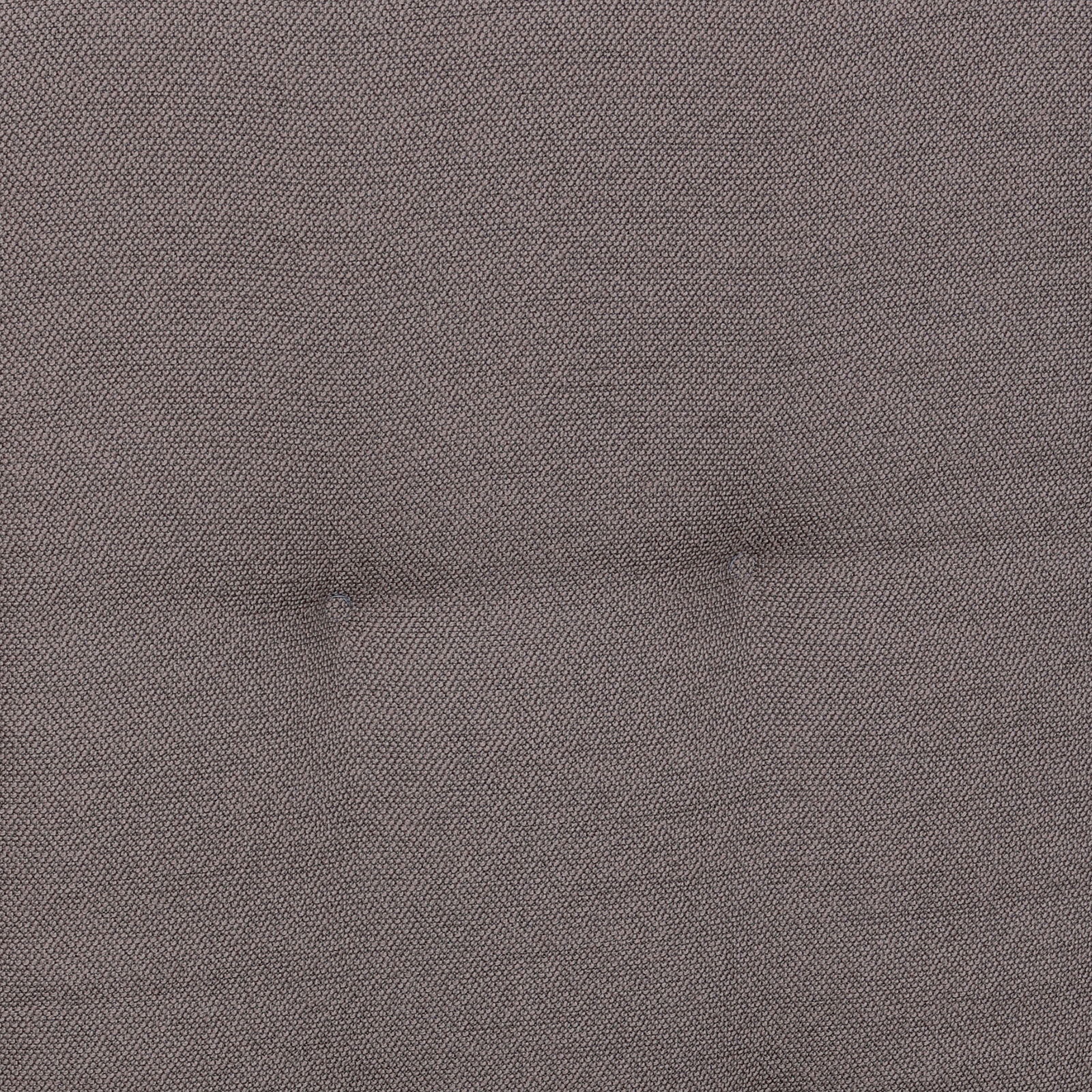 Nahaufnahme der grauen, fein strukturierten Stoffpolsterung mit zwei Knopfheftungen, frontal von oben fotografiert.