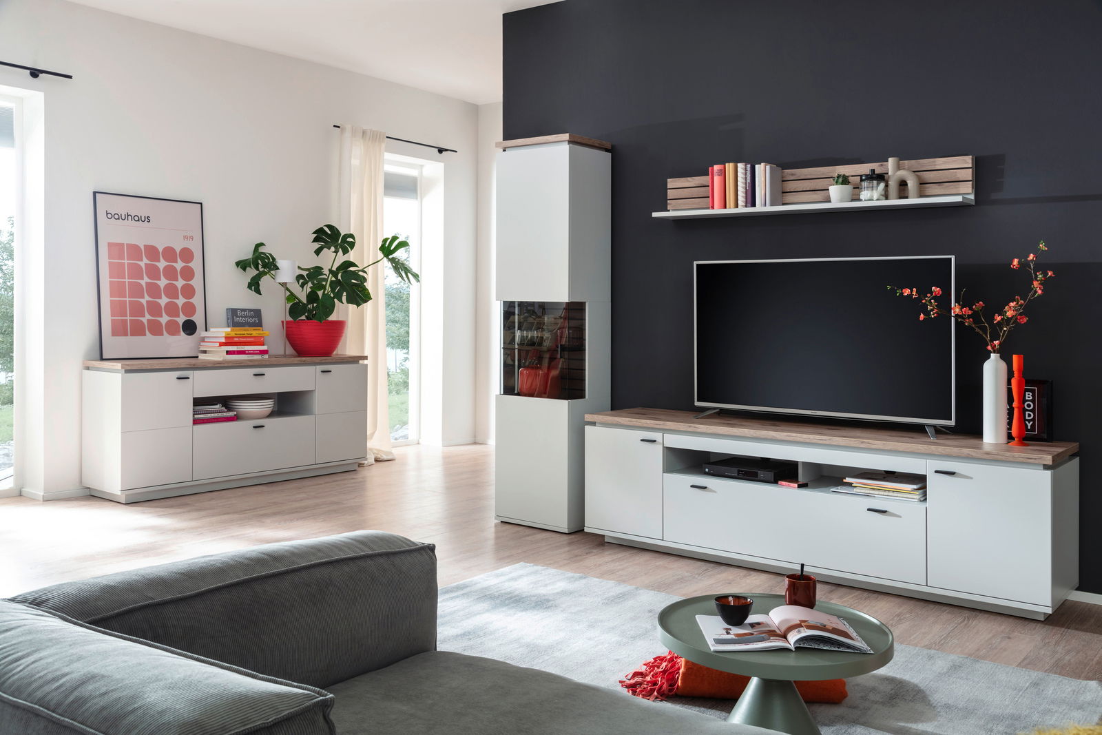 Moderne Wohnzimmer-Wandkombination ESTEPONA in heller Holzoptik mit TV, Regalen und Dekorationen, seitliche Perspektive