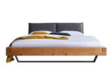 Frontale Ansicht eines Balkenbetts aus Holz mit schwarzem Kopfteil und modernen Metallbeinen, dekoriert mit Kissen und Decke.