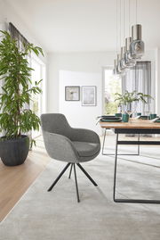 Grauer Armlehnstuhl mit schwarzem Metallgestell in modernem Esszimmer, seitliche Perspektive