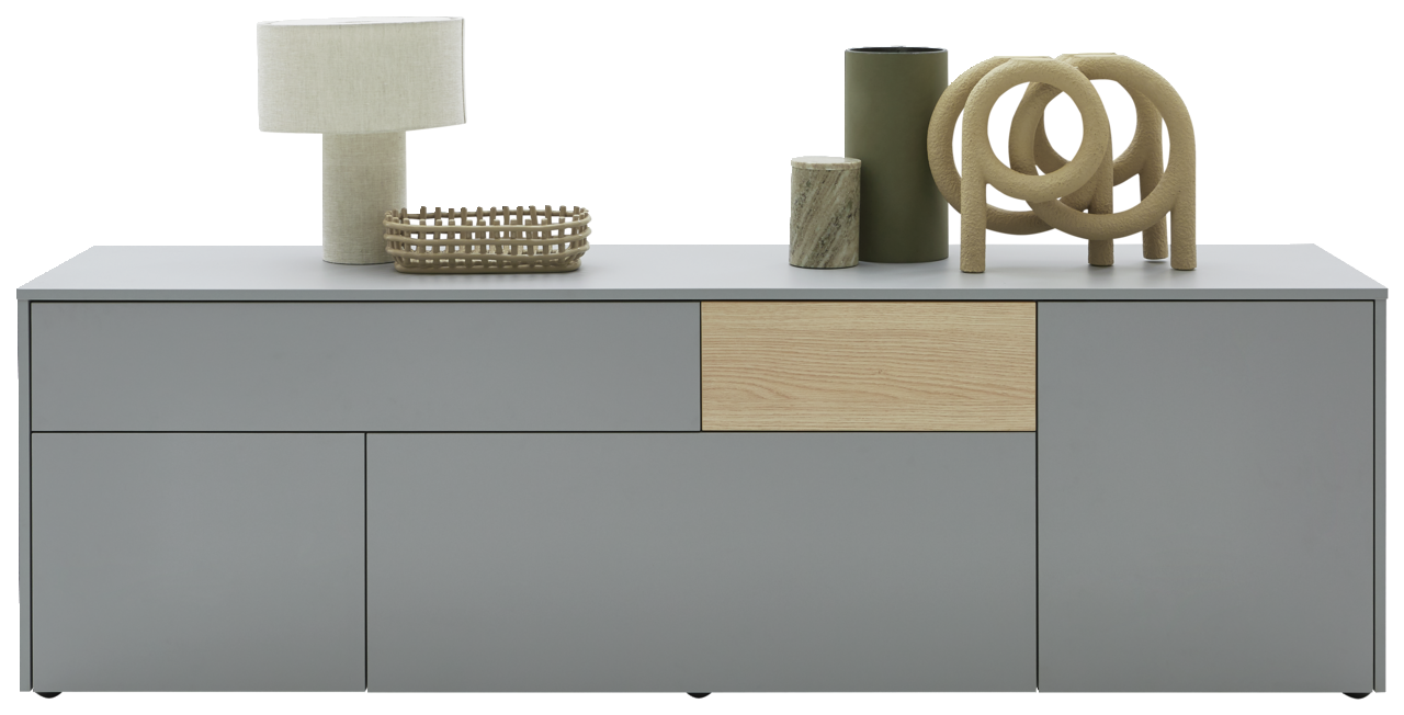 Modernes TV-Lowboard in Grau mit Holzdetails, dekoriert mit einer Tischlampe, einem Korb und Vasen, Frontalansicht.