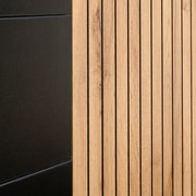 Detailansicht eines XL-Sideboards mit schwarzer und holzfarbener Oberfläche, seitliche Perspektive