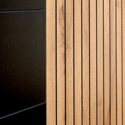 Detailansicht eines XL-Sideboards mit schwarzer und holzfarbener Oberfläche, seitliche Perspektive