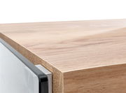 Nahaufnahme einer Ecke eines Eck-Schreibtisches aus Holz mit klaren Linien und moderner Kante, seitliche Perspektive.