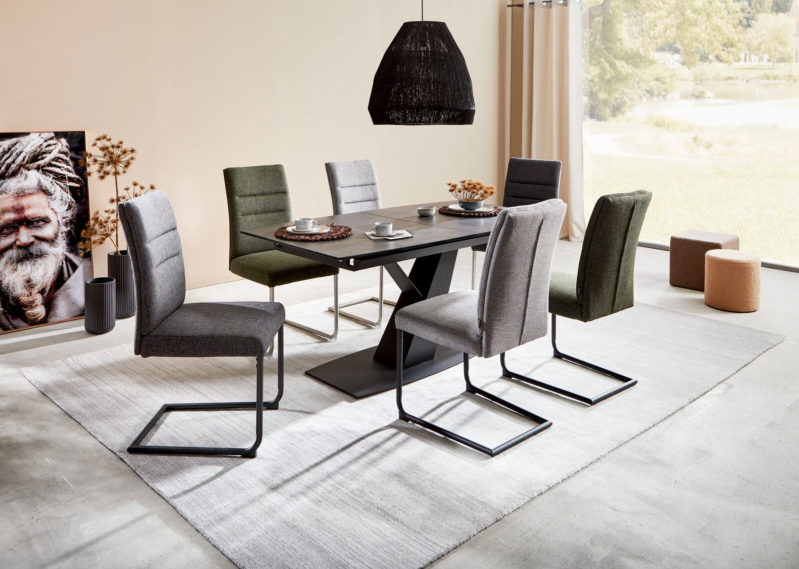 Moderner Esstisch mit sechs gepolsterten Stühlen in verschiedenen Farben, seitliche Perspektive.