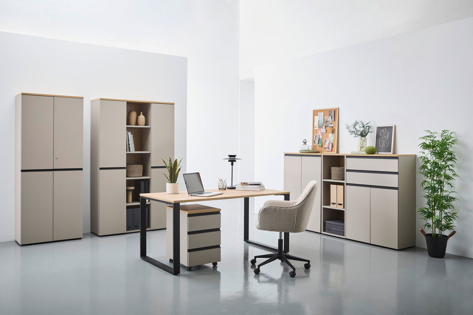 Moderne Büromöbel in einem hellen Raum, bestehend aus einem Schreibtisch mit Rollcontainer, mehreren Aktenschränken und einem Kombischrank. Perspektive von vorne.