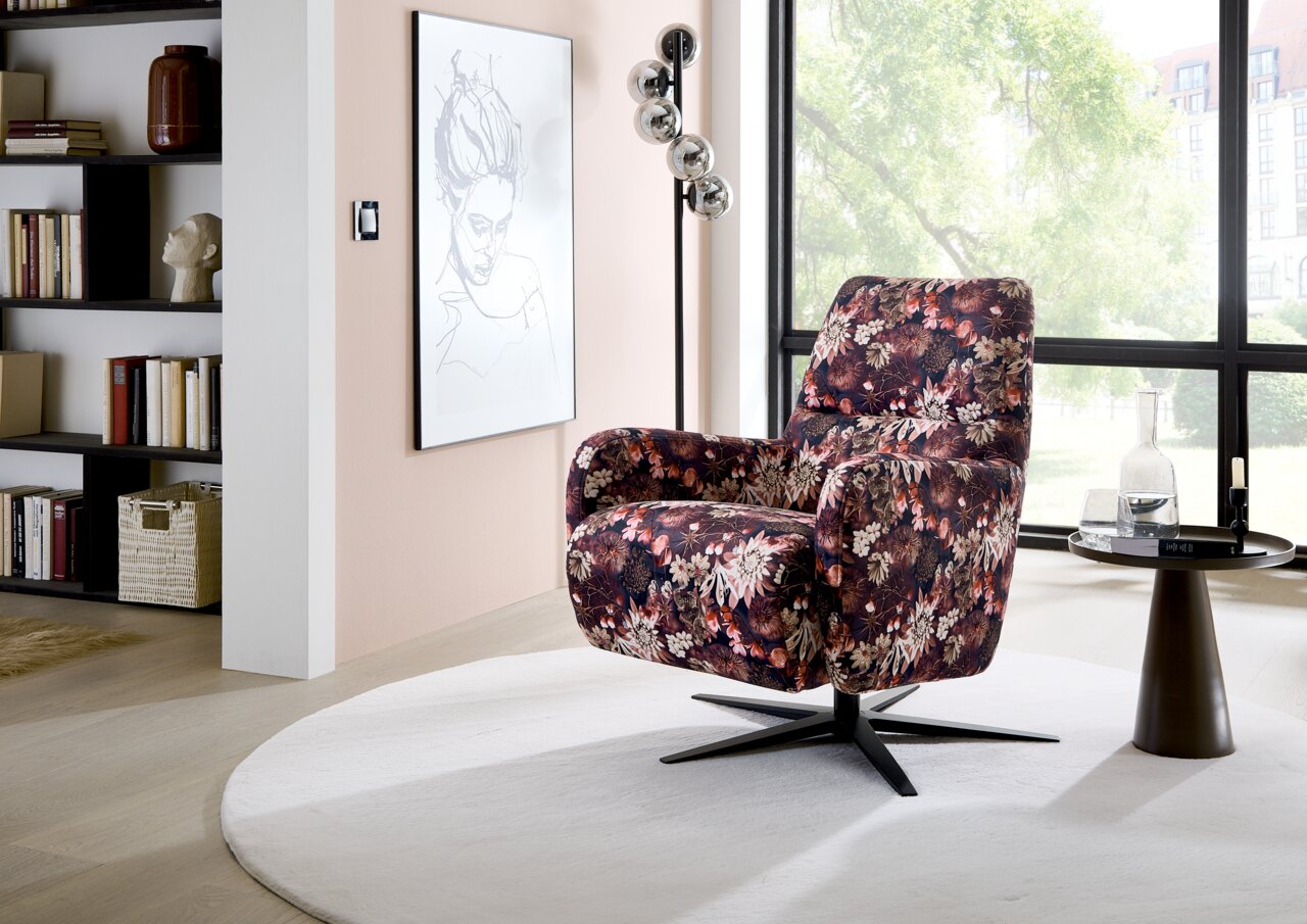 Blumiger Relaxsessel in einem modernen Wohnzimmer, seitliche Perspektive
