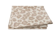 Een gevouwen beige woonkleed met luipaardprint en het opschrift 'JOOP!' in het midden, gefotografeerd van bovenaf.