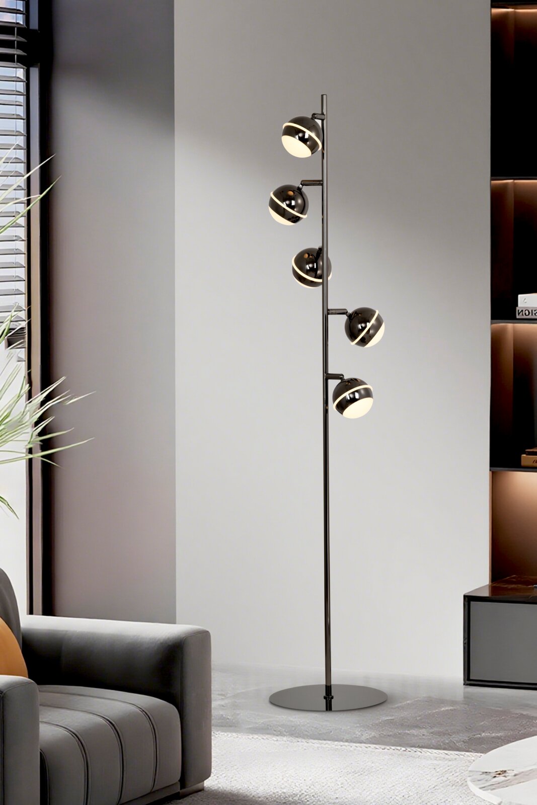 Zwarte moderne vloerlamp met vijf verstelbare bolvormige lichtkoppen en warmwit licht, vanuit schuin vooraanzicht in een stijlvol interieur