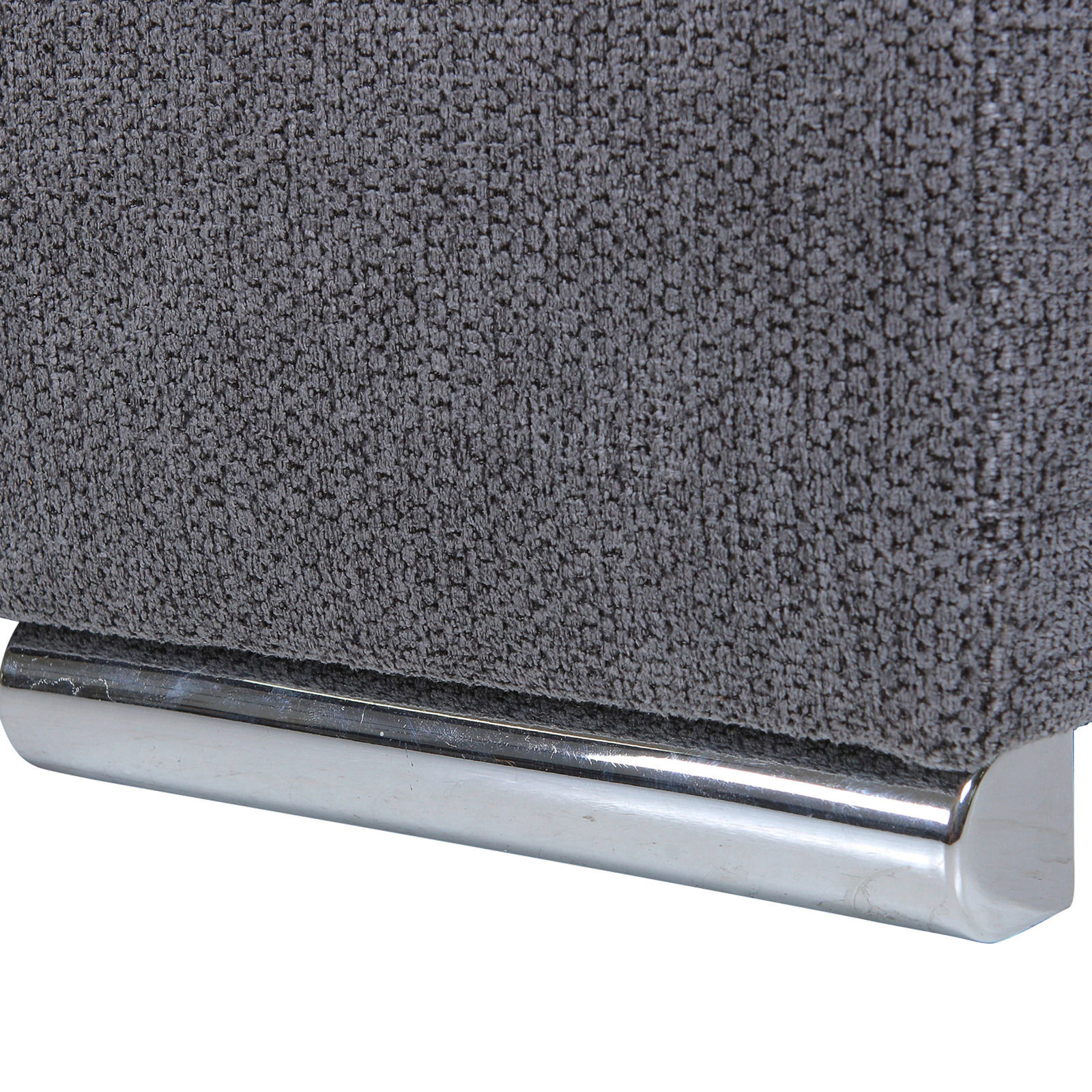 Nahaufnahme eines grauen Stoffsofas mit metallischem Fuß, seitliche Perspektive