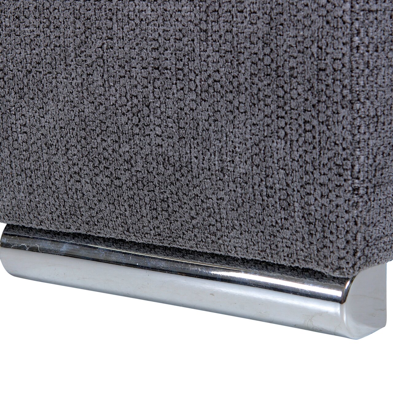 Nahaufnahme eines grauen Stoffsofas mit metallischem Fuß, seitliche Perspektive
