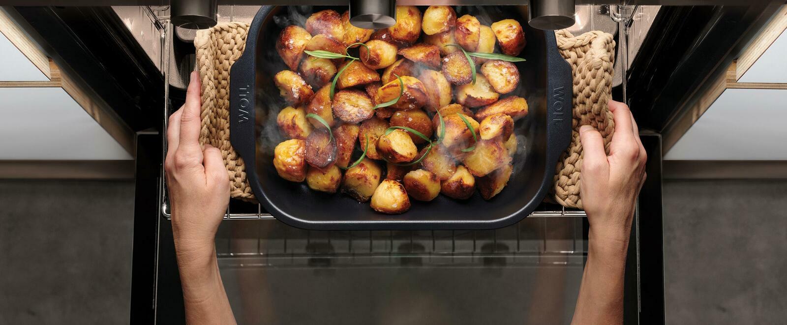 Bratreine mit goldbraun gerösteten Kartoffeln, aus der Vogelperspektive im Ofen gehalten.