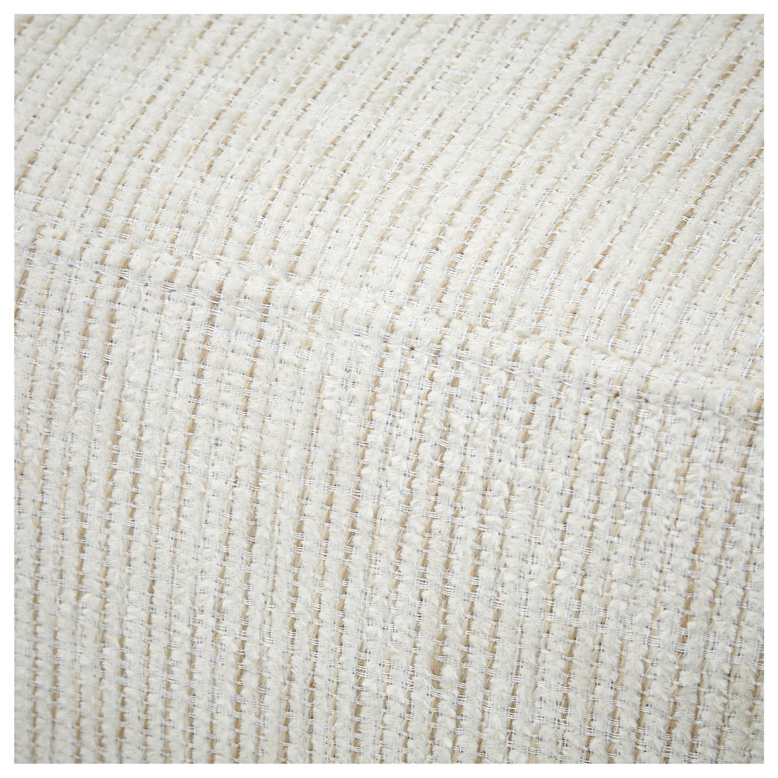 Nahaufnahme der strukturierten, cremefarbenen Stoffoberfläche einer Recamiere aus der Perspektive von oben.