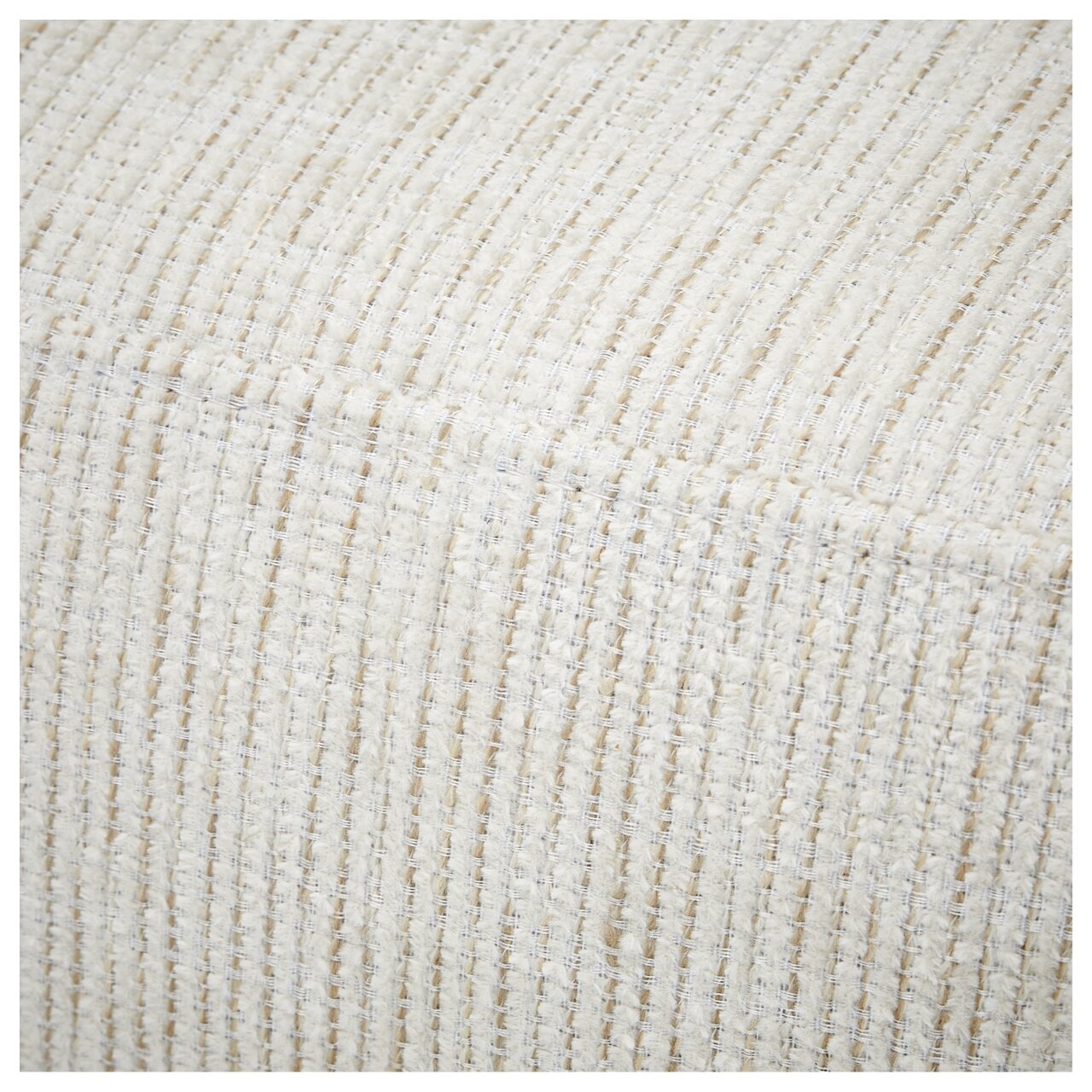 Nahaufnahme der strukturierten, cremefarbenen Stoffoberfläche einer Recamiere aus der Perspektive von oben.