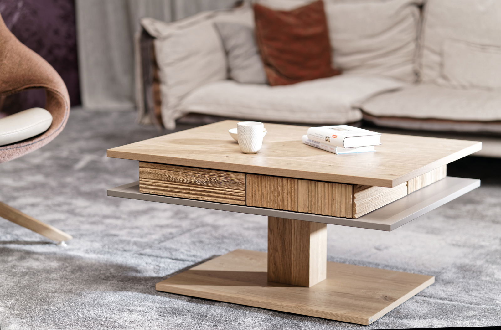 Moderner Couchtisch aus Holz mit Schubladen, seitliche Perspektive, auf einem Teppich vor einem Sofa platziert.